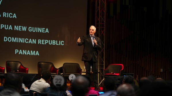John Griffin speaking in front of a projection screen
